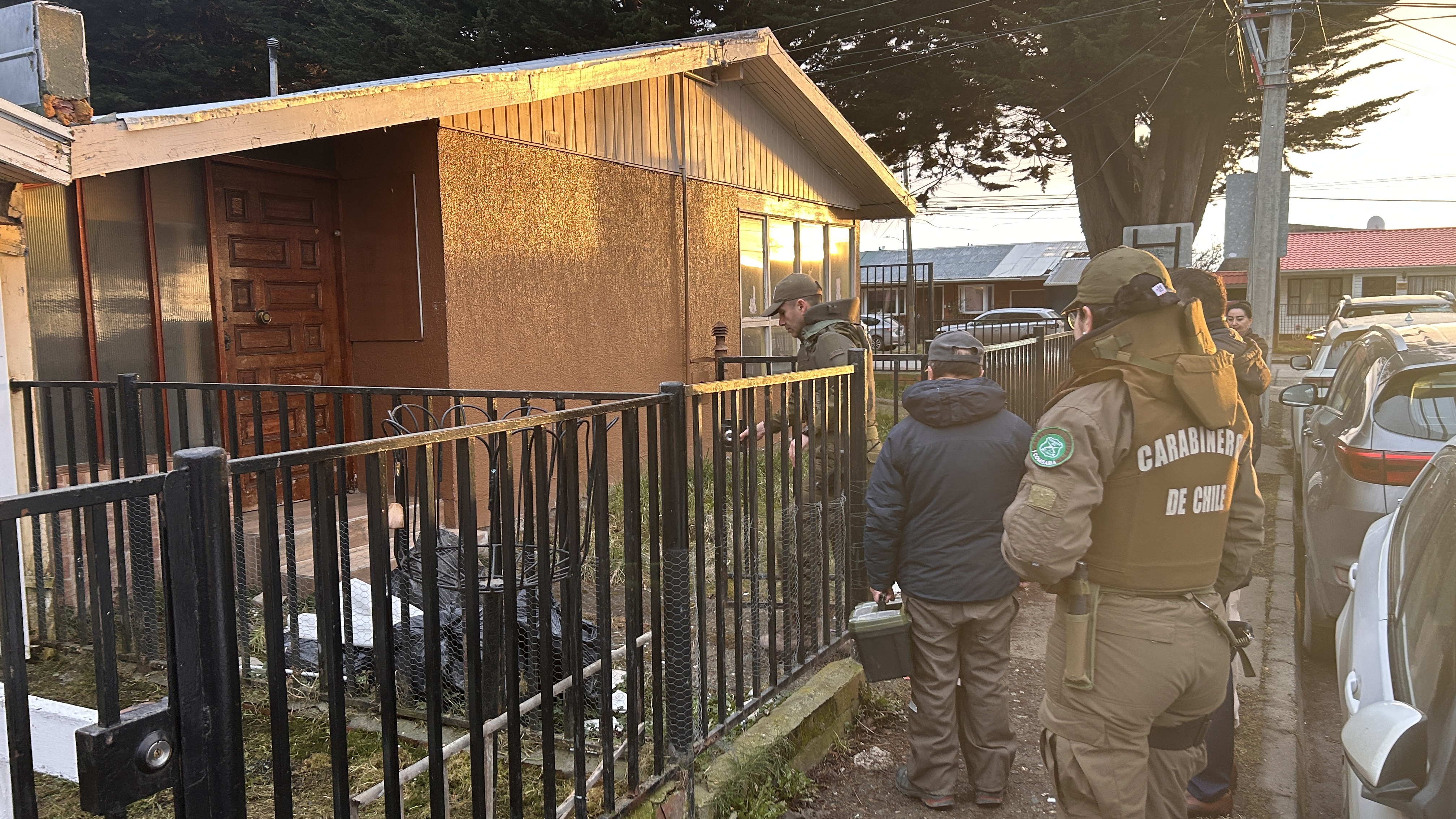 Funcionarios de Serviu Magallanes y Carabineros durante el procedimiento de recuperación de una vivienda fiscal en Punta Arenas.